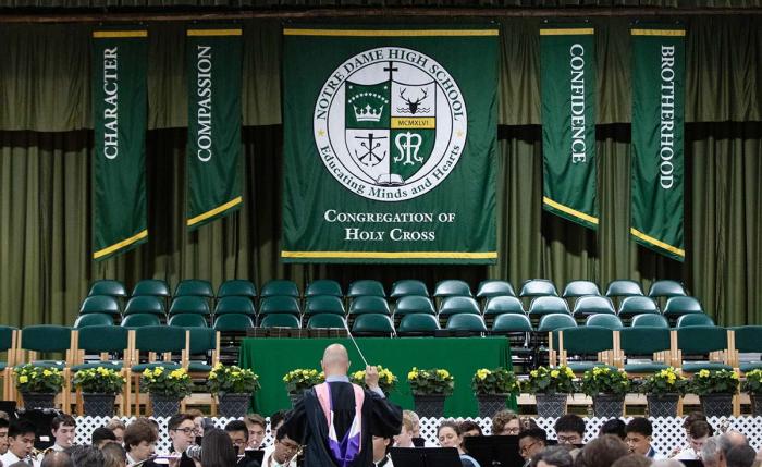 Large vertical hanging banner on a school stage backdrop