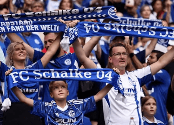 Bulk display of various custom soccer scarves showing different knitting patterns and colors